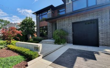 Concrete front yard landscaping with decorative wall with house number